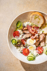 Caesar salad with chicken, bacon, and eggs