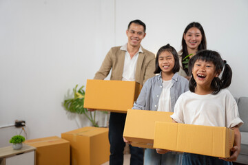 Family moving day joyful children and parents packing boxes in a bright living room