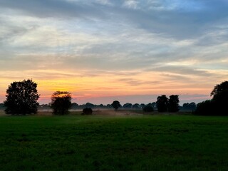 fantastic colorful sky after the sunset, fog at the field, countryside fantastic purple evening