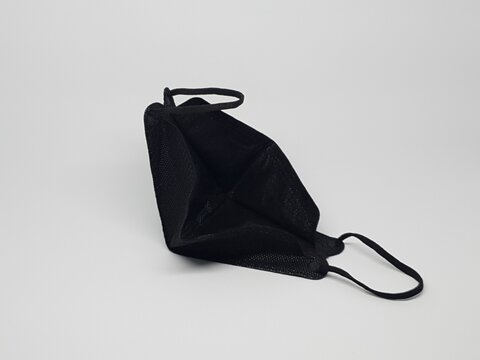 Black reusable cloth face mask isolated on white background, protection against dust and germs