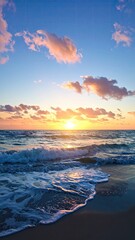 Seascape With Warm Sunlight Reflecting On Ocean Water And Beach Sands Under Blue Sky With Pink Toned Clouds During Sunrise or Sunset