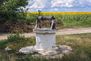 White well near the sunflowers field in Moldova