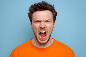 Angry Man Yelling in Orange Shirt Against Blue Background