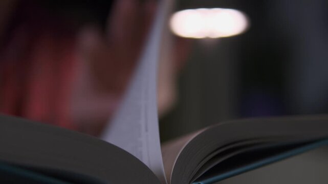 Close up reading book with desk lamp, concept of education, knowledge and self learning at home lifestyle