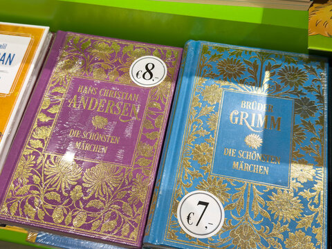Villach, Austria - September 28, 2025: Colorful hardcover books by Hans Christian Andersen and Brothers Grimm displayed on a shelf, showcasing beautiful designs and prices for fairy tale collections