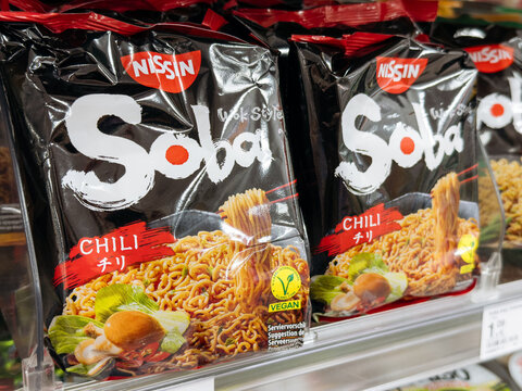 Villach, Austria - September 28, 2025: Nissin Soba Chili instant noodles packaging displayed on supermarket shelf, showcasing vibrant colors and appealing design for culinary enthusiasts