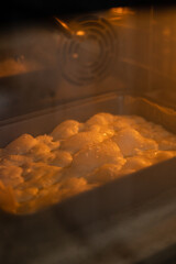 Bread dough rising and baking in the oven with warm golden light