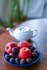 fruit in a ceramic plate and a teapot
