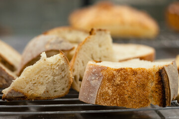 Close up view of sliced artisan sourdough bread pieces placed on a cooling rack in a bakery kitchen.