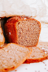 Freshly baked whole grain bread with slices displayed on a clean surface