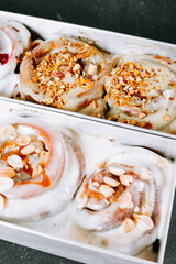 Freshly baked cinnamon rolls topped with nuts and icing ready for serving at a bakery