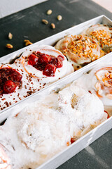 Delicious cinnamon rolls topped with berries and nuts in a bakery display
