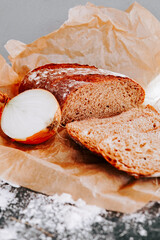 Freshly baked bread with a sliced onion on a rustic wooden table