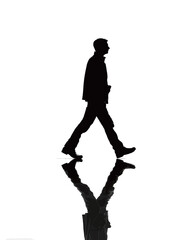 A person walks gracefully across a reflective surface, creating a beautiful silhouette against a bright background. The scene captures a moment of movement and tranquility.