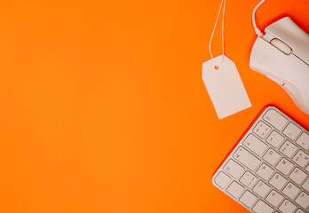 Blank price tag with keyboard and mouse on orange background black friday concept. High quality photo