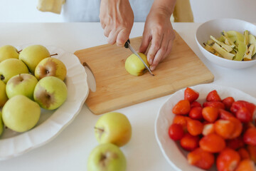 Healthy senior woman in her kitchen. Mature woman serving herself wholesome vegan food at home. Woman taking care of her aging body with a plant-based diet.
