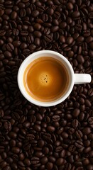 Top view of a cup of strong espresso coffee placed on roasted coffee beans background, rich aroma, dark roast texture, morning energy, caffeine boost, perfect beverage for coffee lovers