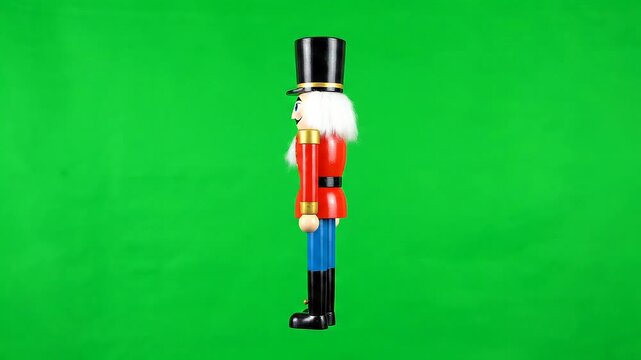 A traditional wooden nutcracker soldier doll shown in profile against a solid green screen background for chroma keying.
