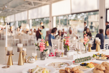 Elegant buffet setting at a celebration with fresh flowers and gourmet dishes, creating a warm and inviting atmosphere for guests enjoying the gathering