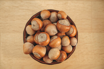 Freshly harvested hazelnuts in a rustic bowl on a wooden table