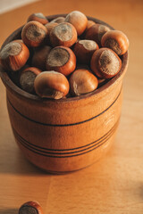Beautiful wooden bowl filled with fresh hazelnuts on a table