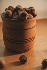 Wooden bowl filled with fresh hazelnuts on a smooth surface