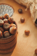 Natural hazelnuts in a rustic wooden bowl on a warm kitchen table