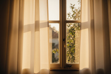 Sunlit interior with sheer curtains and warm morning light