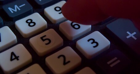 A finger presses the calculator buttons. Close-up shot - Powered by Adobe