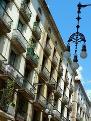 Beautiful historic buildings with balconies are seen under a clear blue sky.