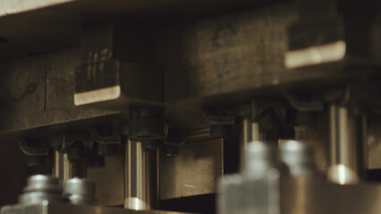 Industrial metal press showing intricate machine parts and components, highlighting the details of modern manufacturing and advanced precision engineering processes in a factory setting