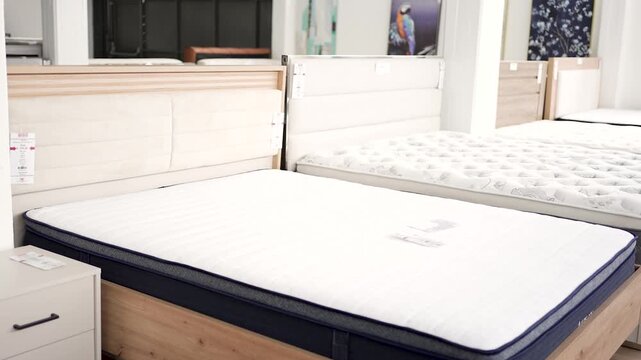 Customers browse a collection of mattresses in a sleep store, comparing styles and features. Many options are available for those seeking better sleep quality.