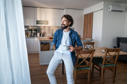 Young man enjoying morning coffee at home