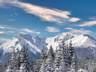 Naklejka premium clouds over the snow-covered mountain peaks