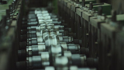 Obraz premium Metal rollers in a manufacturing facility precisely shaping and bending sheet metal on an assembly line, representing industrial production and precision engineering processes