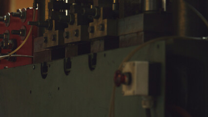 Industrial machine components operating in a factory environment, performing an automatic process with precision and efficiency, highlighting the mechanics of production