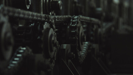 Fototapeta premium Industrial equipment working, featuring a detailed view of interlocking metal chains and gear sprockets demonstrating power transmission and continuous motion in a factory setting