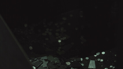 Small metal fragments and electronic parts glowing in scattered patterns over a dark surface, symbolizing technology, data, and digital processes within a manufacturing or industrial context