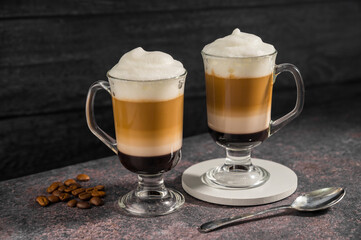 Layered coffee latte drinks. Hot coffee drinks in glass mugs, dark background