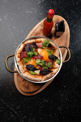 Two Skillets of Savory Pancake with Meats and Hot Sauce