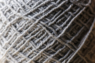 Cozy gray yarn texture with soft wool fiber ball for knitting craft project. Macro detail of thread with warm, natural background, perfect for handmade hobbies