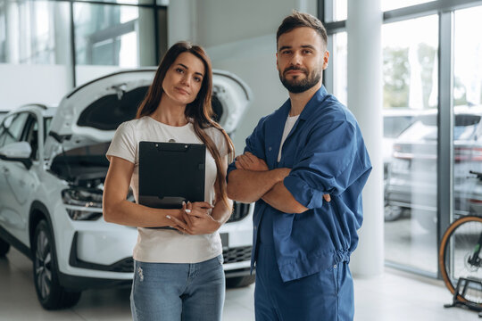Woman customer is in the car repair service station with mechanic