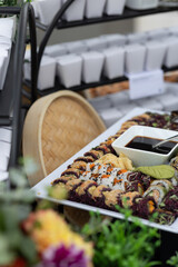 vegan sushi platter with soy sauce being served at catered outdoor event 