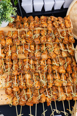 grilled chicken teriyaki skewers on platter being served at outdoor event