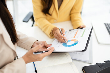 Two colleagues engaged in business analytics,  over financial charts. Colleagues Collaborating on Business Analytics.