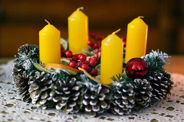 advent wreath decorated with candles, candy canes, dried oranges and pine cones