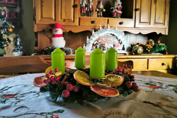 advent wreath decorated with candles, candy canes, dried oranges and pine cones