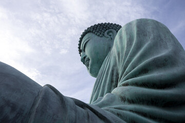 Massive bronze Buddha statue embodies profound peace and spiritual serenity. ancient monument,...
