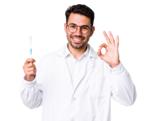 A smiling man in a lab coat holds a toothbrush in one hand and makes an "OK" gesture with the other.