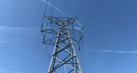 Electric Power Transmission Tower Against Clear Blue Sky With High Voltage Lines